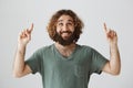 Guy is confessing in love under girlfriend balcony. Portrait of cheerful attractive eastern guy with beard looking and