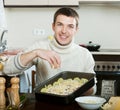 Guy cooking french-style meat at kitchen