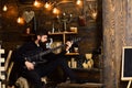 Guy in cozy warm atmosphere play relaxing soul music. Man bearded musician enjoy evening with bass guitar, wooden Royalty Free Stock Photo