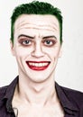 Guy with crazy joker face, green hair and idiotic smike. carnaval costume