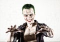 Guy with crazy joker face, green hair and idiotic smike. carnaval costume