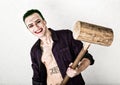 Guy with crazy joker face, green hair and idiotic smile. carnaval costume. holding hammer for cricket Royalty Free Stock Photo