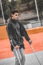 Guy on crutches walking in park Royalty Free Stock Photo
