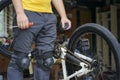 Guy cyclist stands near the bike with a screwdriver and a rag in his hands Royalty Free Stock Photo