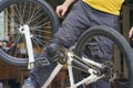 Guy cyclist stands near the bike with a screwdriver and a rag in his hands Royalty Free Stock Photo