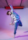 Cool guy dancing contemporary dance in studio. Neon light background. Acrobatic bboy dancer. Break dance lessons. Royalty Free Stock Photo