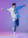 Cool guy dancing contemporary dance in studio. Neon light background. Acrobatic bboy dancer. Break dance lessons. Royalty Free Stock Photo