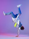 Cool guy dancing contemporary dance in studio. Neon light background. Acrobatic bboy dancer. Break dance lessons. Royalty Free Stock Photo