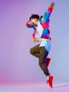 Guy dancing contemporary dance in studio. Neon light grey background. Acrobatic bboy dancer. Break dance lessons. Royalty Free Stock Photo