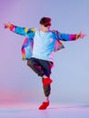Guy dancing contemporary dance in studio. Neon light grey background. Acrobatic bboy dancer. Break dance lessons. Royalty Free Stock Photo