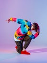 Guy dancing contemporary dance in studio. Neon light grey background. Acrobatic bboy dancer. Break dance lessons. Royalty Free Stock Photo