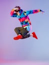 Guy dancing contemporary dance in studio. Neon light grey background. Acrobatic bboy dancer. Break dance lessons. Royalty Free Stock Photo