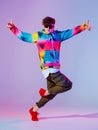 Guy dancing contemporary dance in studio. Neon light grey background. Acrobatic bboy dancer. Break dance lessons. Royalty Free Stock Photo