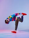 Guy dancing contemporary dance in studio. Neon light grey background. Acrobatic bboy dancer. Break dance lessons. Royalty Free Stock Photo