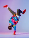 Guy dancing contemporary dance in studio. Neon light grey background. Acrobatic bboy dancer. Break dance lessons. Royalty Free Stock Photo