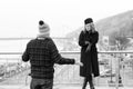 Guy delayed to date. Woman shows times on arm. Man spread his hand out on bridge and walking area Royalty Free Stock Photo