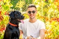 Guy with a dog walks in a park in autumn Royalty Free Stock Photo