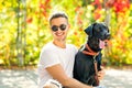 Guy with a dog walks in a park in autumn Royalty Free Stock Photo