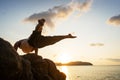 Guy doing acrobatic yoga at sunset by the sea Royalty Free Stock Photo