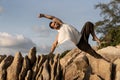 Guy doing yoga poses on sharp rocks near the beach in thailand