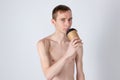 Naked handsome guy drink from coffee or tea cup. Morning refreshment and drink