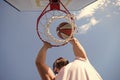 guy dunking basketball ball through net ring with hands, winning Royalty Free Stock Photo