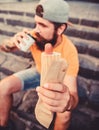 Guy eating hot dog. Man bearded bite tasty sausage and drink paper cup. Street food so good. Urban lifestyle nutrition