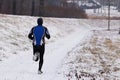 The guy is engaged in jogging in sportswear in the winter nature. Extreme weather conditions for sports and a healthy lifestyle.