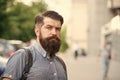 Guy exploring city. Comfortable tourism. Summer vacation. Hipster wearing backpack urban street background. Bearded man Royalty Free Stock Photo