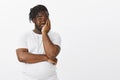 Guy feeling embarrassed for girlfriend behaviour. Shocked displeased attractive dark-skinned guy in white t-shirt