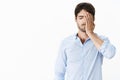 Guy feeling sad missing opportunity of lifetime being guilty and upset making facepalm gesture with hand on face Royalty Free Stock Photo