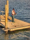 A guy fishing at a floating dock