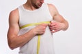 Guy with flexible ruler around chest on white background