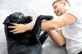 Guy freelancer with his dog labrador playing at home