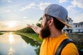 Guy in front of blue sky at evening time admire landscape. Man in cap enjoy sunset while stand on bridge. Take moment to