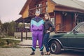 Guy and girl in clothes of the nineties, next to the old car Royalty Free Stock Photo