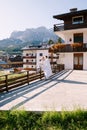 A guy and a girl cuddle with a blanket outside a hotel in the mountains. Cortina Ampezzo is an Italian city in province