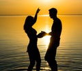 The guy and the girl are dancing at sunset background, silhouettes Royalty Free Stock Photo