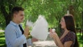 A guy and a girl in eating cotton candy in a city park Royalty Free Stock Photo