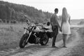 The guy with the girl in a field on a motorcycle