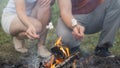 Guy and the girl are frying marshmallows on a campfire. Friends hold sticks with marshmallows over a bonfire. Royalty Free Stock Photo