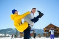 Guy and a girl are having fun in the courtyard of a cottage in a ski resort.