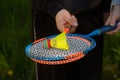 A guy and a girl are holding colorful badminton rackets. On the rackets there is a bright multi-colored flan