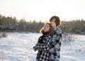 Guy and girl, hugging, enjoying each other in a snow-covered park at sunset in winter Royalty Free Stock Photo