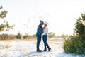 The guy with the girl kiss in the winter in the woods against the background of falling candy. Romantic winter atmosphere