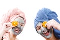 A guy with a girl looks at the camera and hold orange slices near the face , mask for skin man and woman, guy with a girl make a Royalty Free Stock Photo