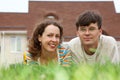 Guy with girl lying on lawn in front of new home Royalty Free Stock Photo