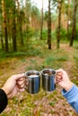 A guy and a girl on a picnic in the forest are holding mugs of tea. Royalty Free Stock Photo