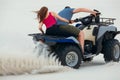 The guy and the girl ride a quad bike in the desert, having fun and enjoying, a couple of lovers Royalty Free Stock Photo