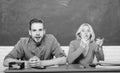 Guy and girl sit at desk in classroom. Wondering about result. Studying in college or university. Couple friends Royalty Free Stock Photo